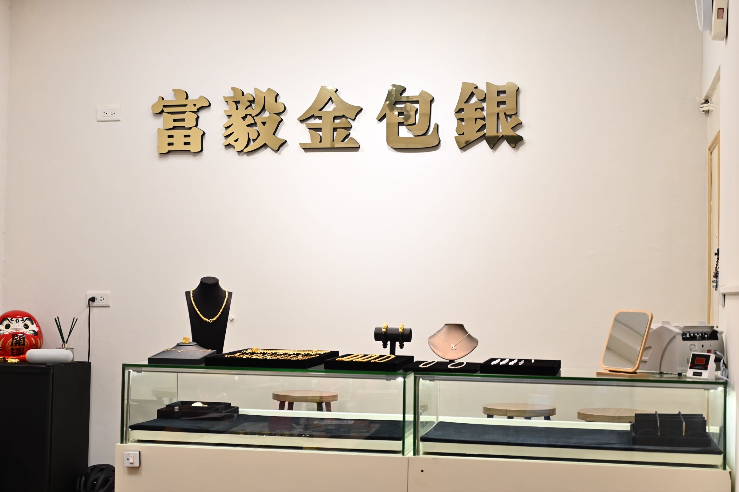 富毅金包銀淡水門市店內,展示櫃與品牌牆